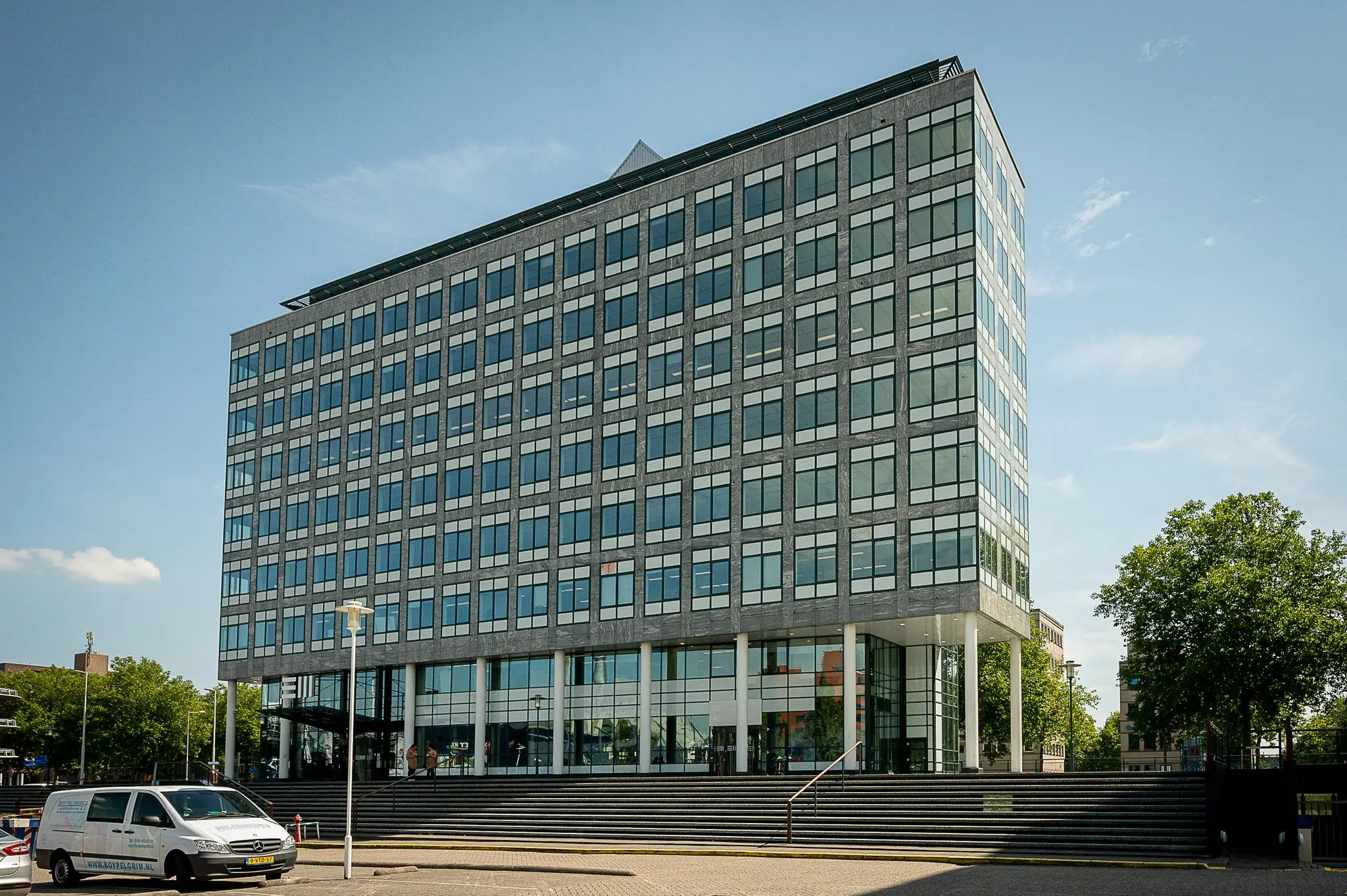 Modern kantoorgebouw aan de Watermanweg met glazen gevel en trappenpartij aan de voorzijde.