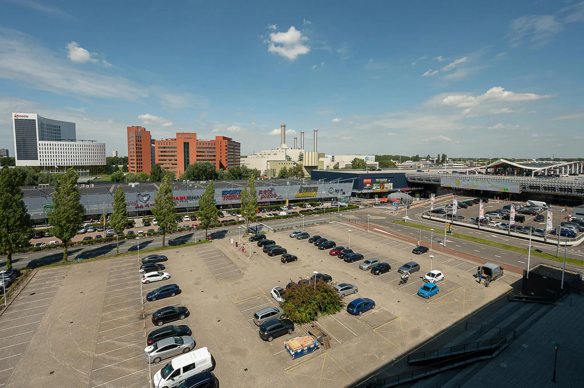 Parkeerterrein aan de Watermanweg in Rotterdam met op de achtergrond kantoren, winkels en het Alexandrium winkelcentrum.