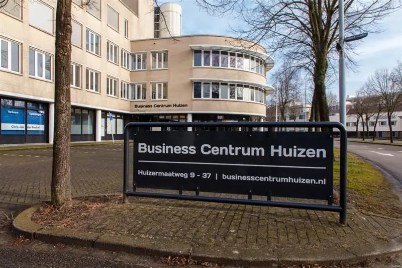 Ingang van het Business Centrum Huizen aan de Huizermaatweg met duidelijk zichtbaar informatiebord.