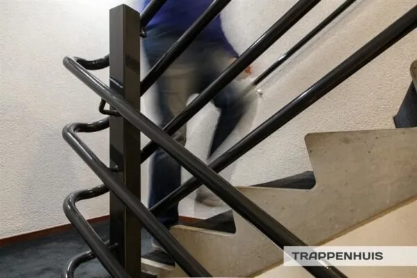 Persoon loopt een trap op in een trappenhuis aan de Huizermaatweg.
