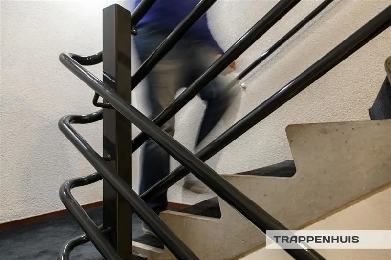 Persoon loopt een trap op in een trappenhuis aan de Huizermaatweg.