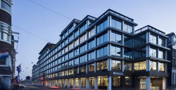 Modern kantoorgebouw van Spaces aan de Vijzelstraat in Amsterdam bij schemering.