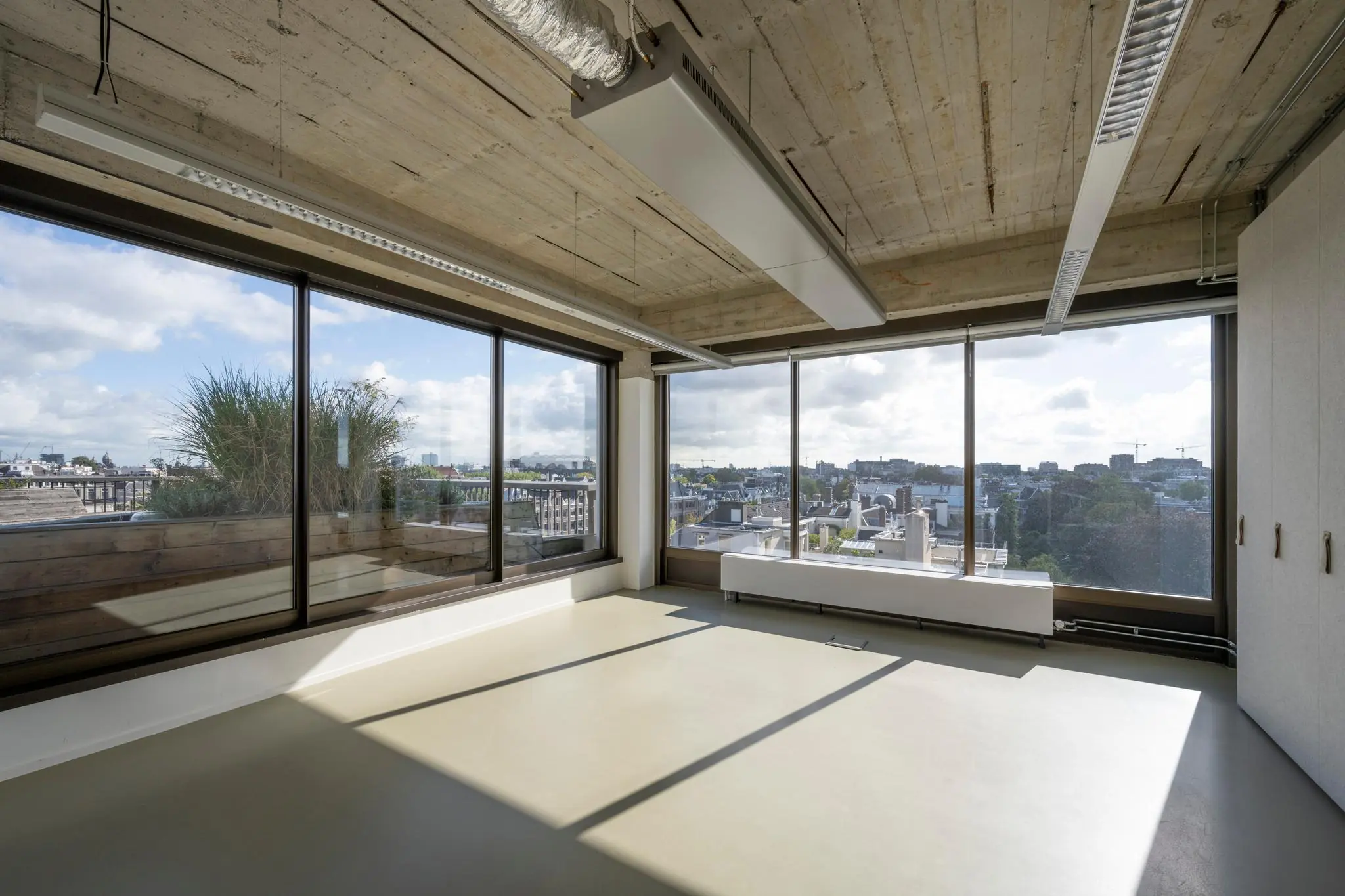 Licht en modern kantoorinterieur aan de Vijzelstraat met grote ramen en uitzicht over de stad.