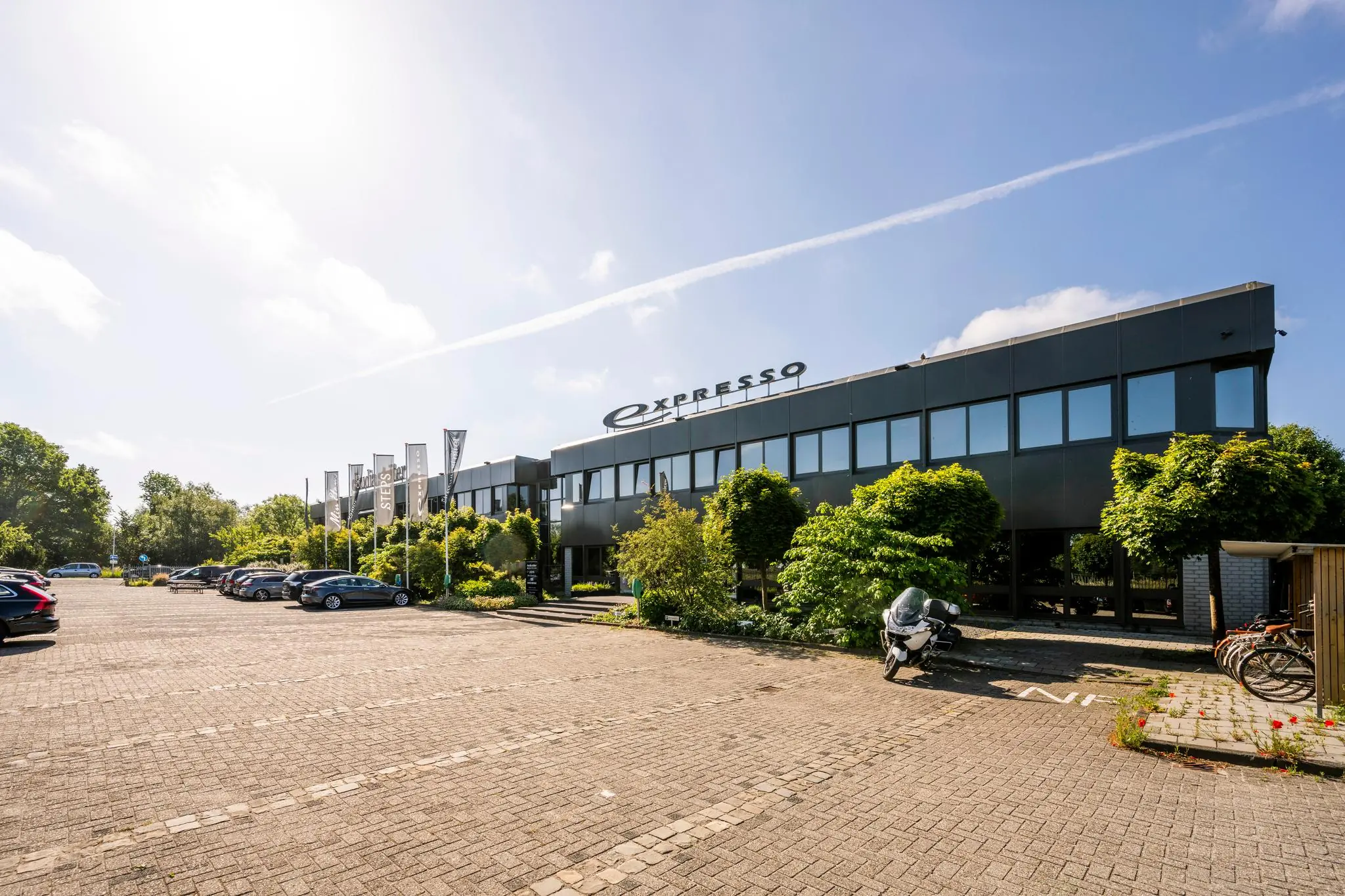Zonovergoten parkeerterrein met het moderne kantoorgebouw van Expresso aan de Stammerhove.