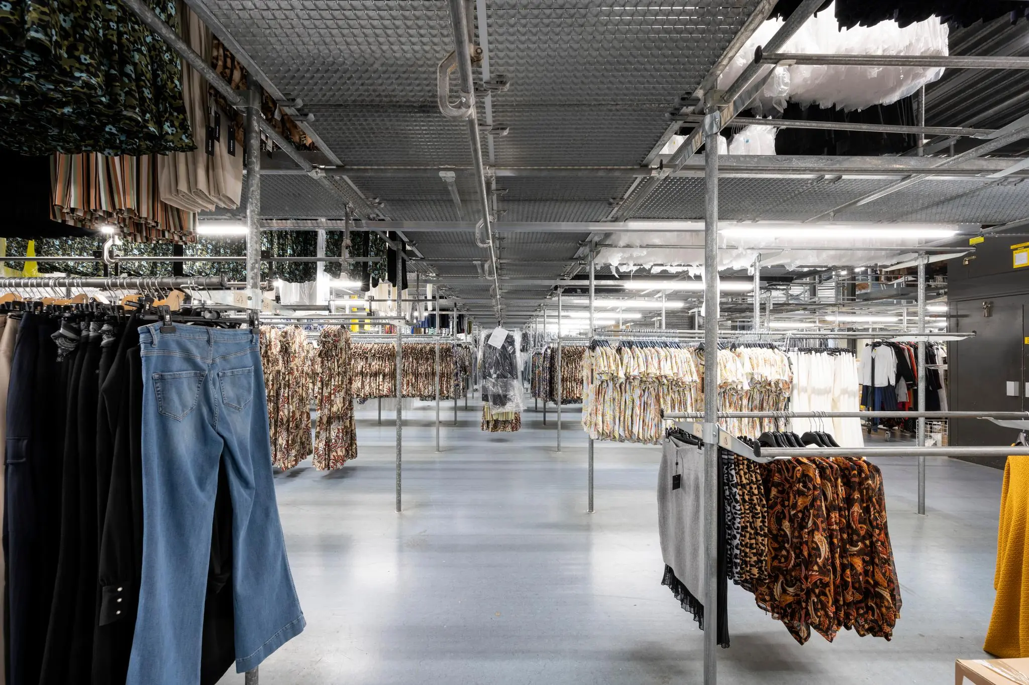 Rekken met gesorteerde kleding in een modern distributiecentrum van Stammerhove.