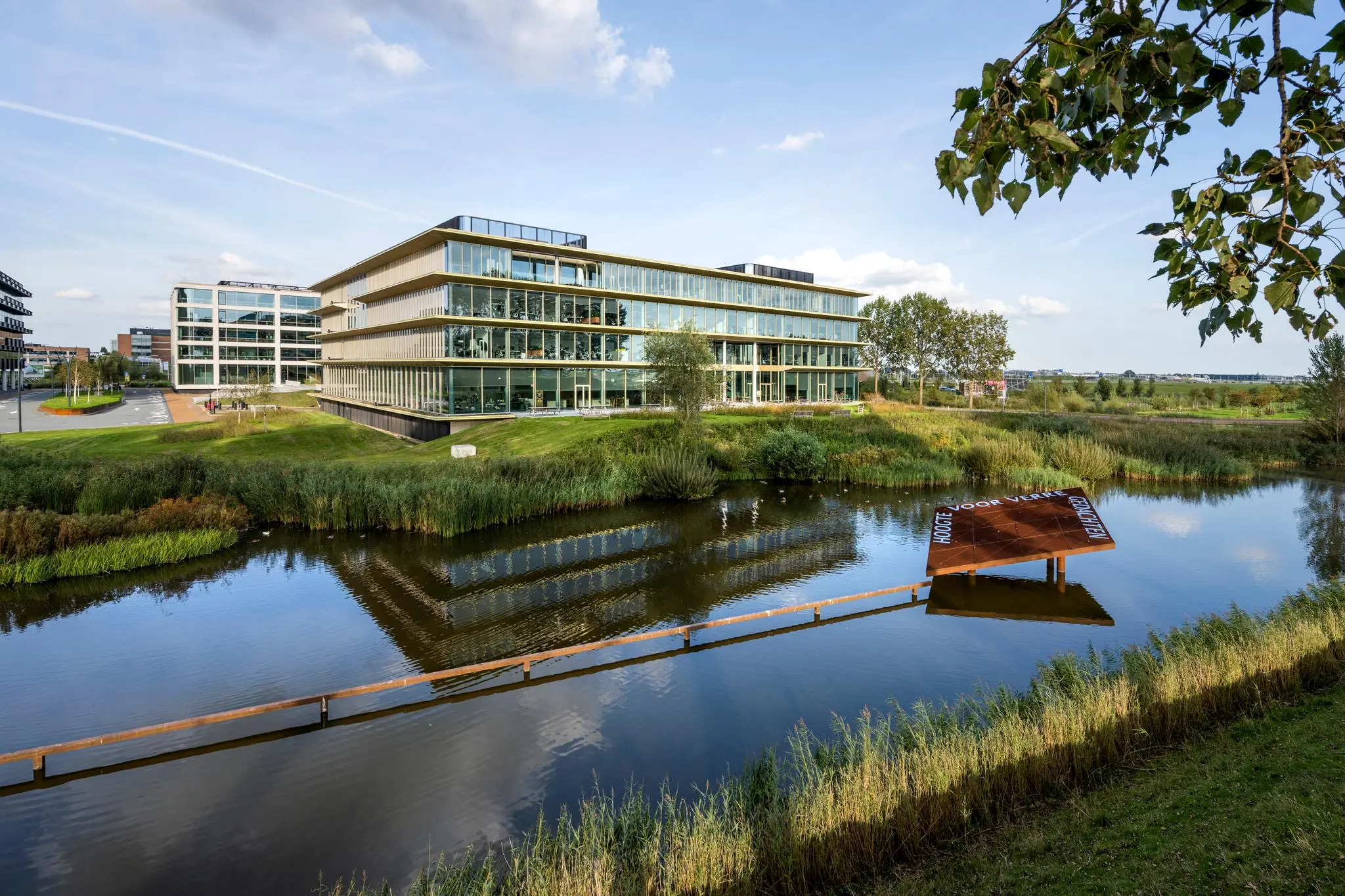 Modern kantoorgebouw aan Taurusavenue in Hoofddorp met glazen gevels en waterpartij op de voorgrond.