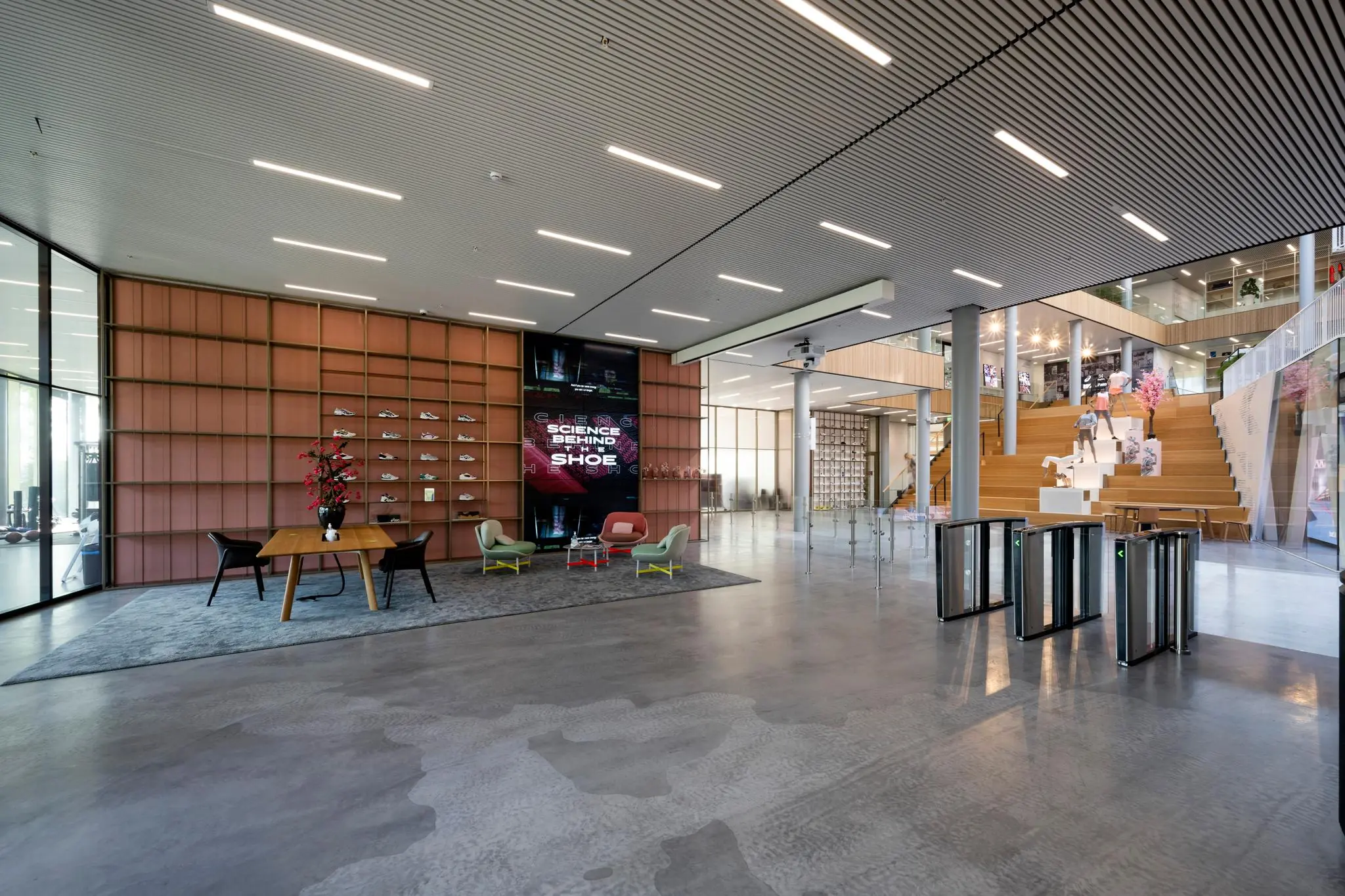 Moderne entreehal van een kantoorgebouw aan Taurusavenue met een schoenenexpositie, zitgedeelte en houten tribune.