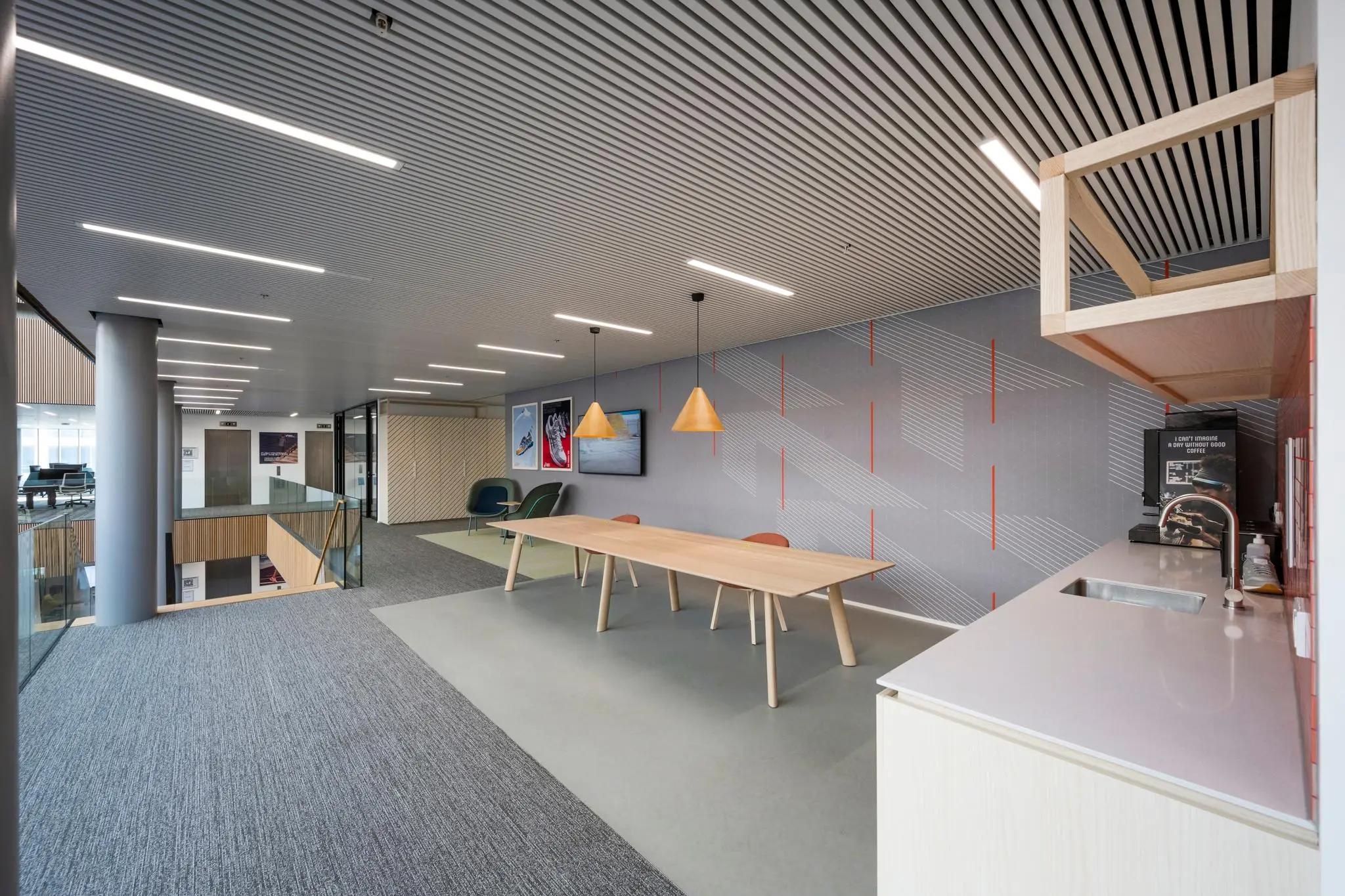 Moderne kantoorruimte aan Taurusavenue met zitgedeelte, lange houten tafel en kitchenette.