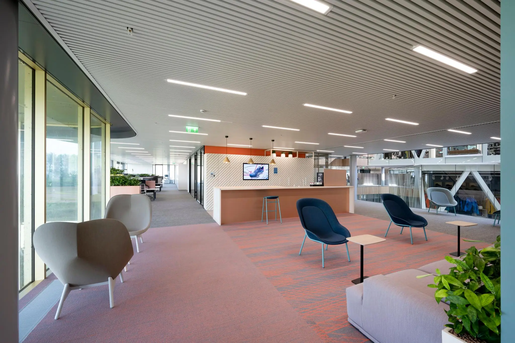 Moderne kantoorlobby op Taurusavenue met kleurrijk meubilair en een strakke, open inrichting.