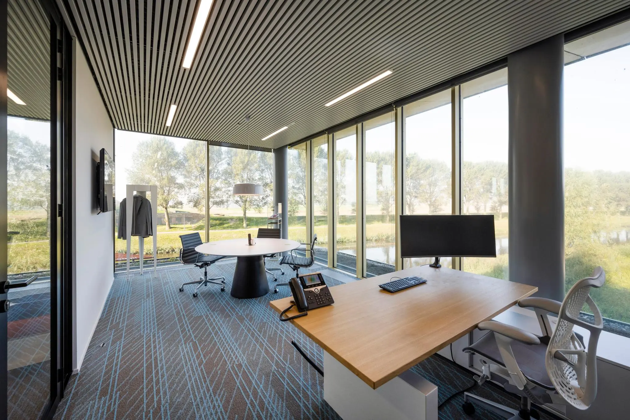 Modern ingericht kantoor aan Taurusavenue met grote ramen en uitzicht op groen landschap.