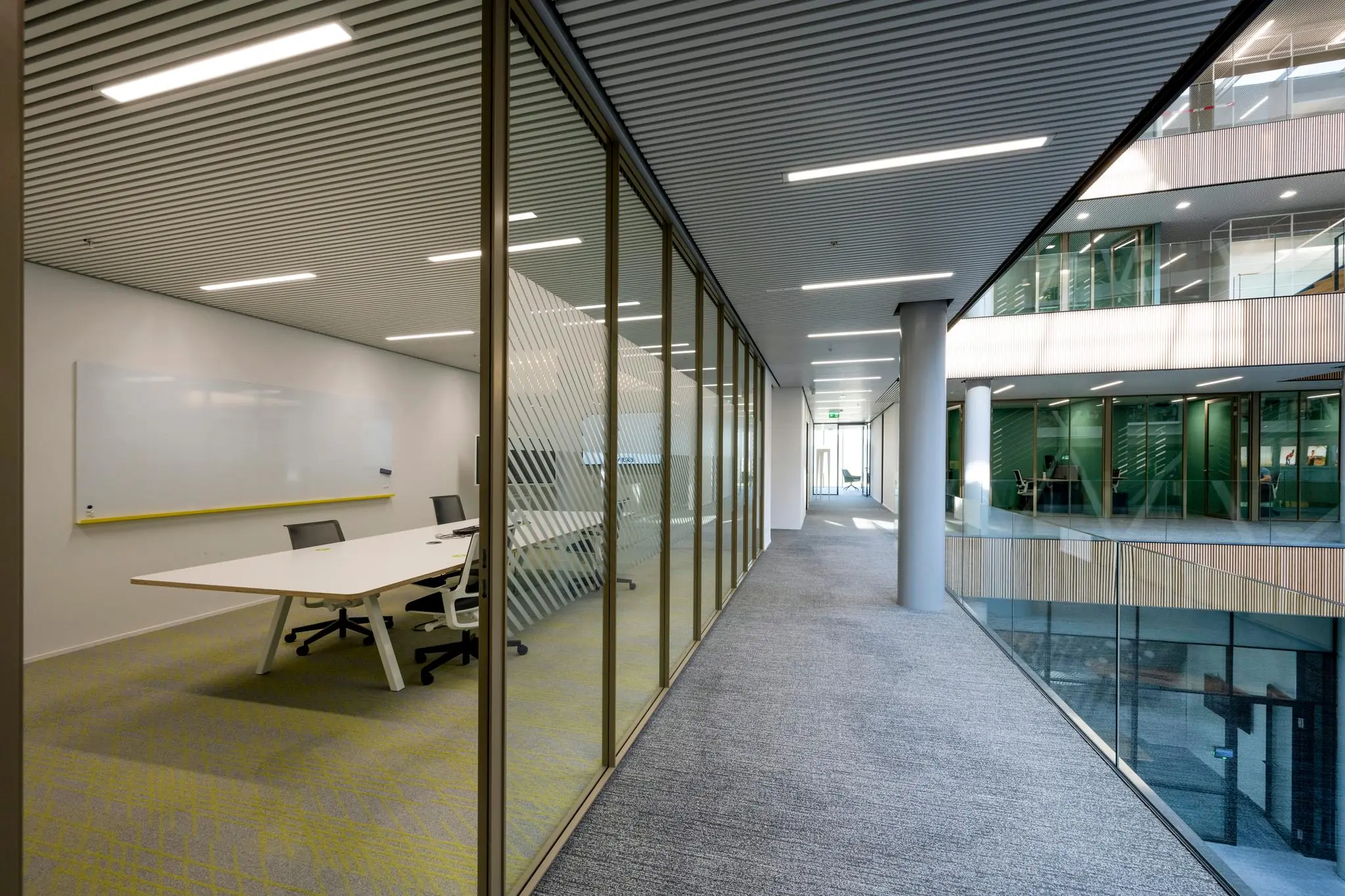 Moderne kantoorruimte aan Taurusavenue met glazen wanden, vergaderruimte en ruim opgezette gang.