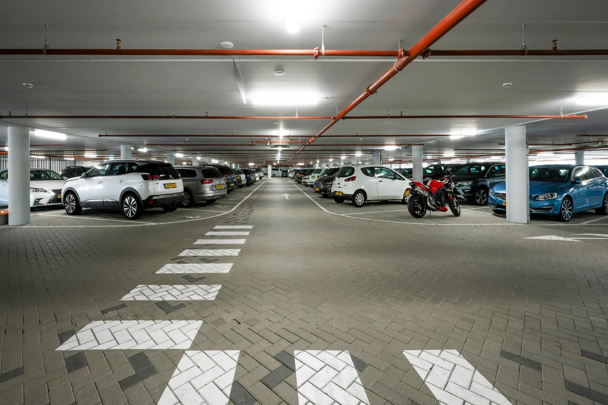 Ondergrondse parkeergarage aan de Taurusavenue met geparkeerde auto's en een motorfiets.