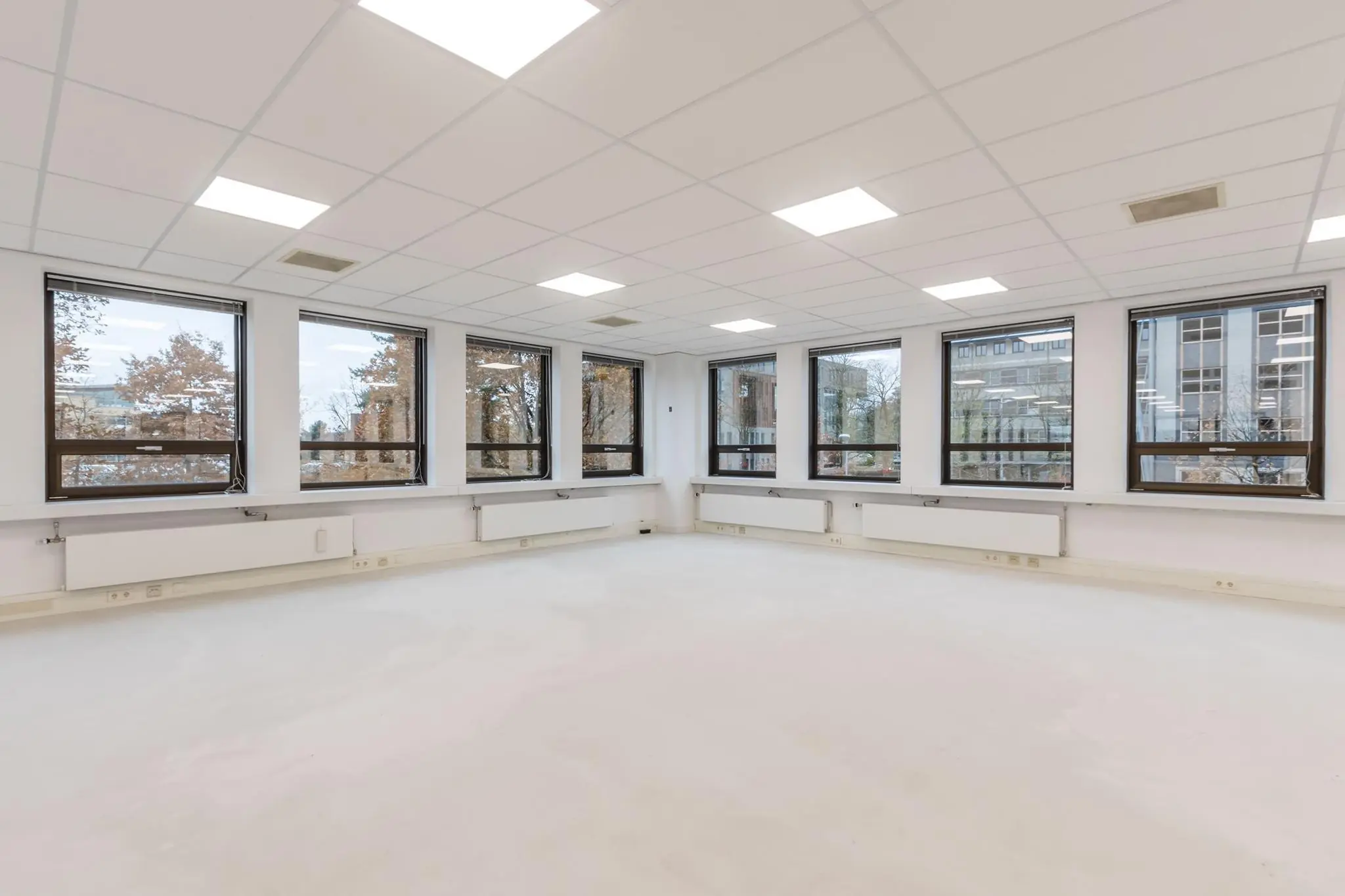 Lichte, lege kantoorkamer met grote ramen en systeemplafond in gebouw Marathon.