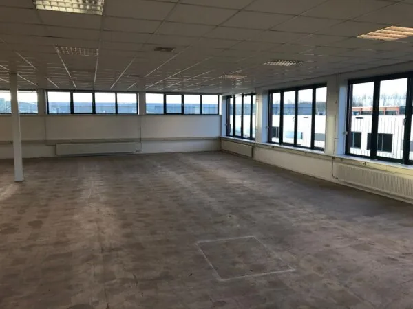 Lege kantoorruimte met systeemplafond en grote ramen aan de Sydneystraat.