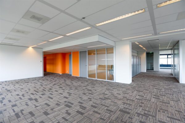 Moderne lege kantoorruimte aan het Bogaardplein met glazen wanden en oranje accenten.