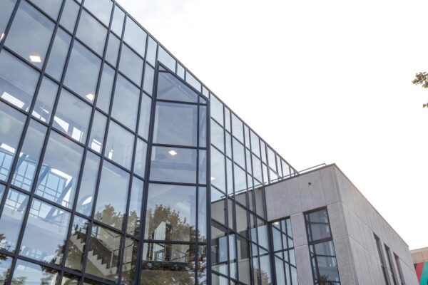 Modern kantoorgebouw aan de Volmerlaan met grote glazen gevel en betonnen elementen.