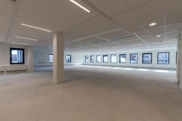 Leeg en ruim kantoorpand aan de Volmerlaan met veel ramen en moderne plafondverlichting.