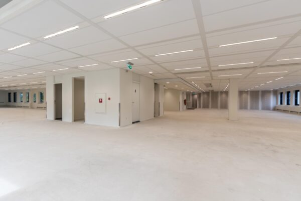 Leeg, modern kantoorpand aan de Volmerlaan met strakke witte afwerking en systeemplafond.