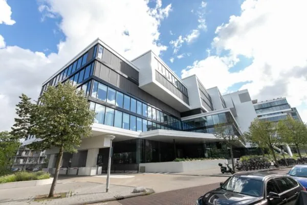 Modern kantoorgebouw met veel glas en opvallende architectuur aan een stadsstraat, getiteld 979_2160.