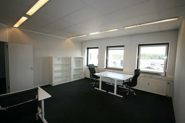 Licht en modern kantoor op de Corkstraat met twee bureaus, zwarte bureaustoelen en witte kasten.