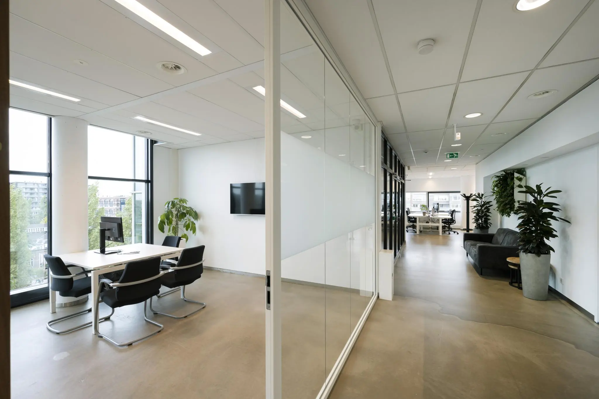 Modern kantoorinterieur in Rietlandpark met vergaderruimte, glazen wanden, zitgedeelte en grote ramen.