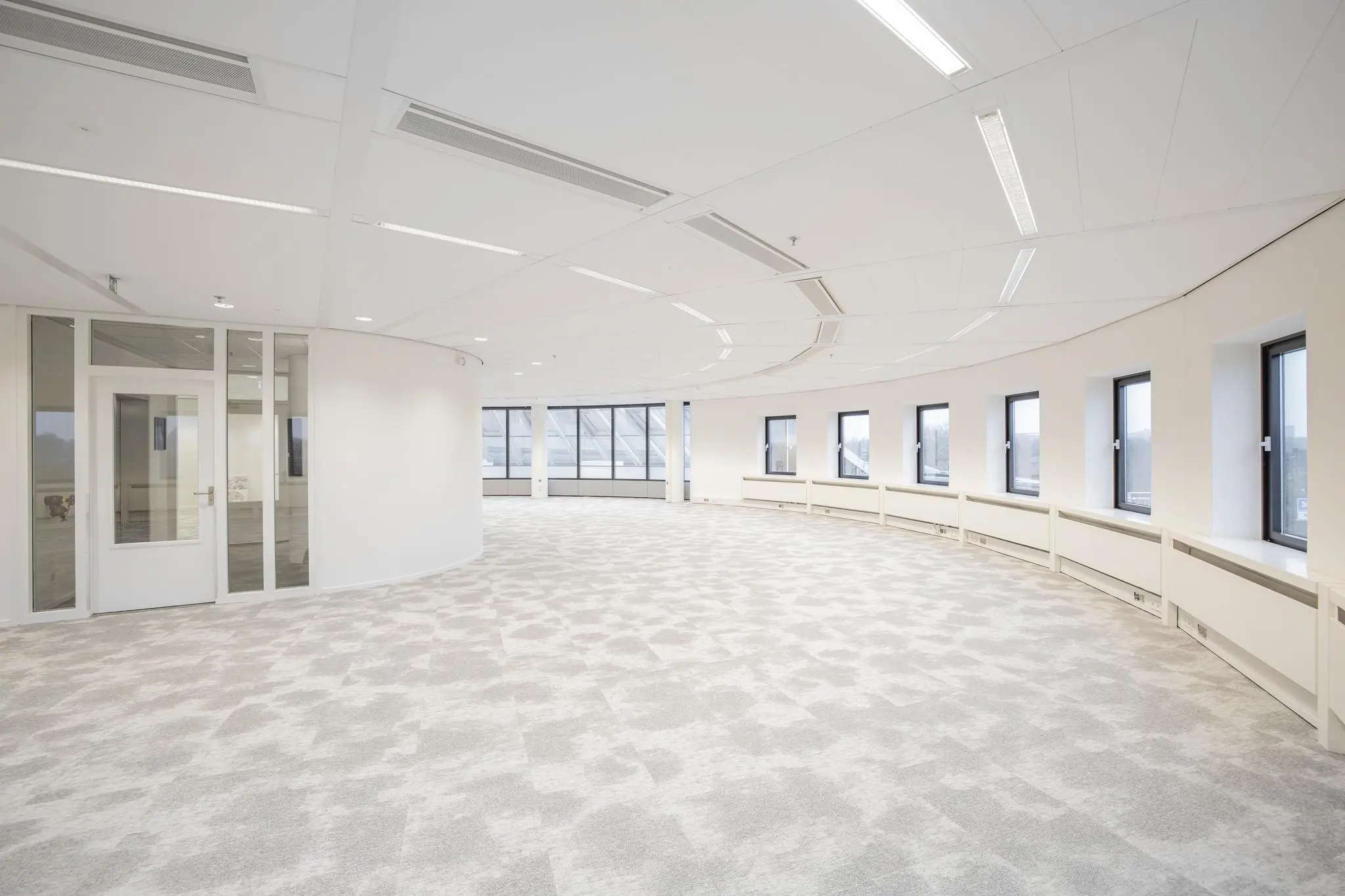 Licht en modern kantoorpand aan de Euclideslaan met gebogen ramenwand en glazen kantoorruimte.