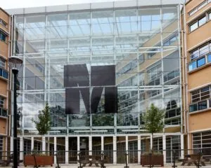 Glazen gevel van het Media Park-gebouw met groot zwart M-logo in het midden.