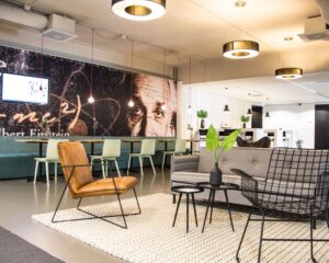 Moderne lounge- en werkruimte met een muurschildering van Albert Einstein op de achtergrond.