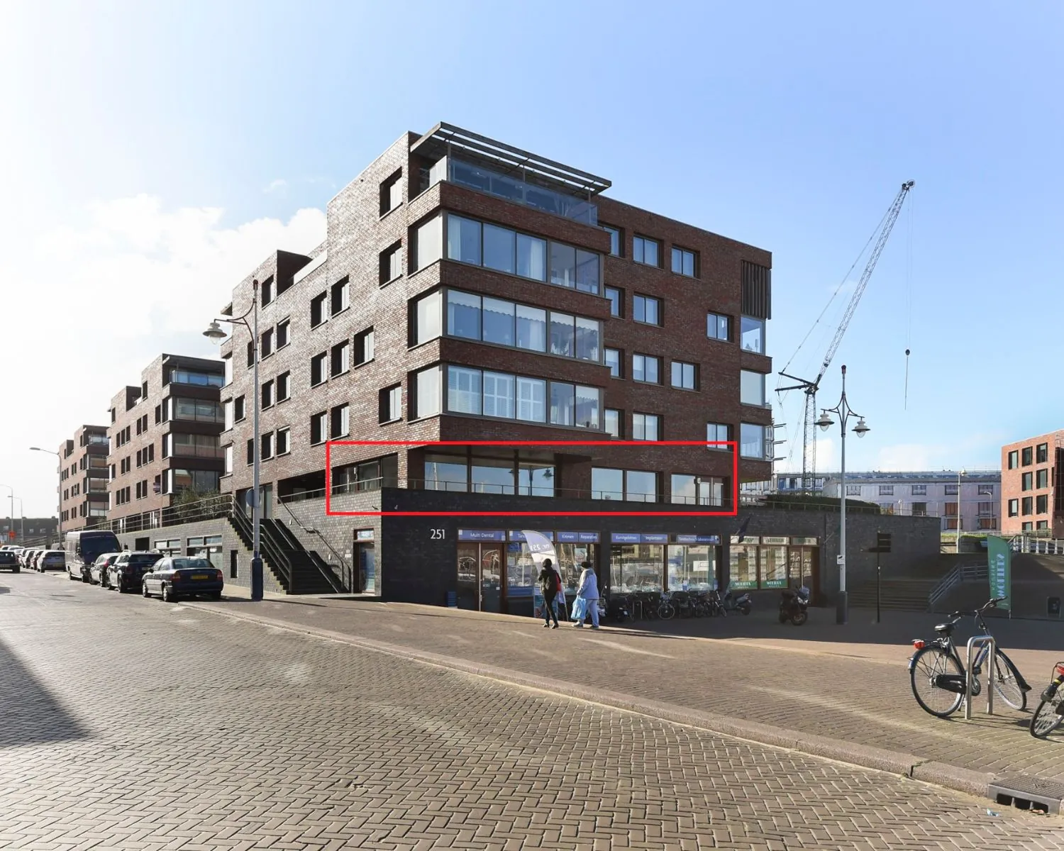 Appartement op de eerste verdieping aan de Dr. Lelykade 257 in Den Haag, gemarkeerd met een rood kader in een modern hoekgebouw.