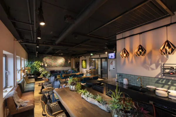 Gezellige pantry foyer van de Academie met planten, zithoeken en warme verlichting.