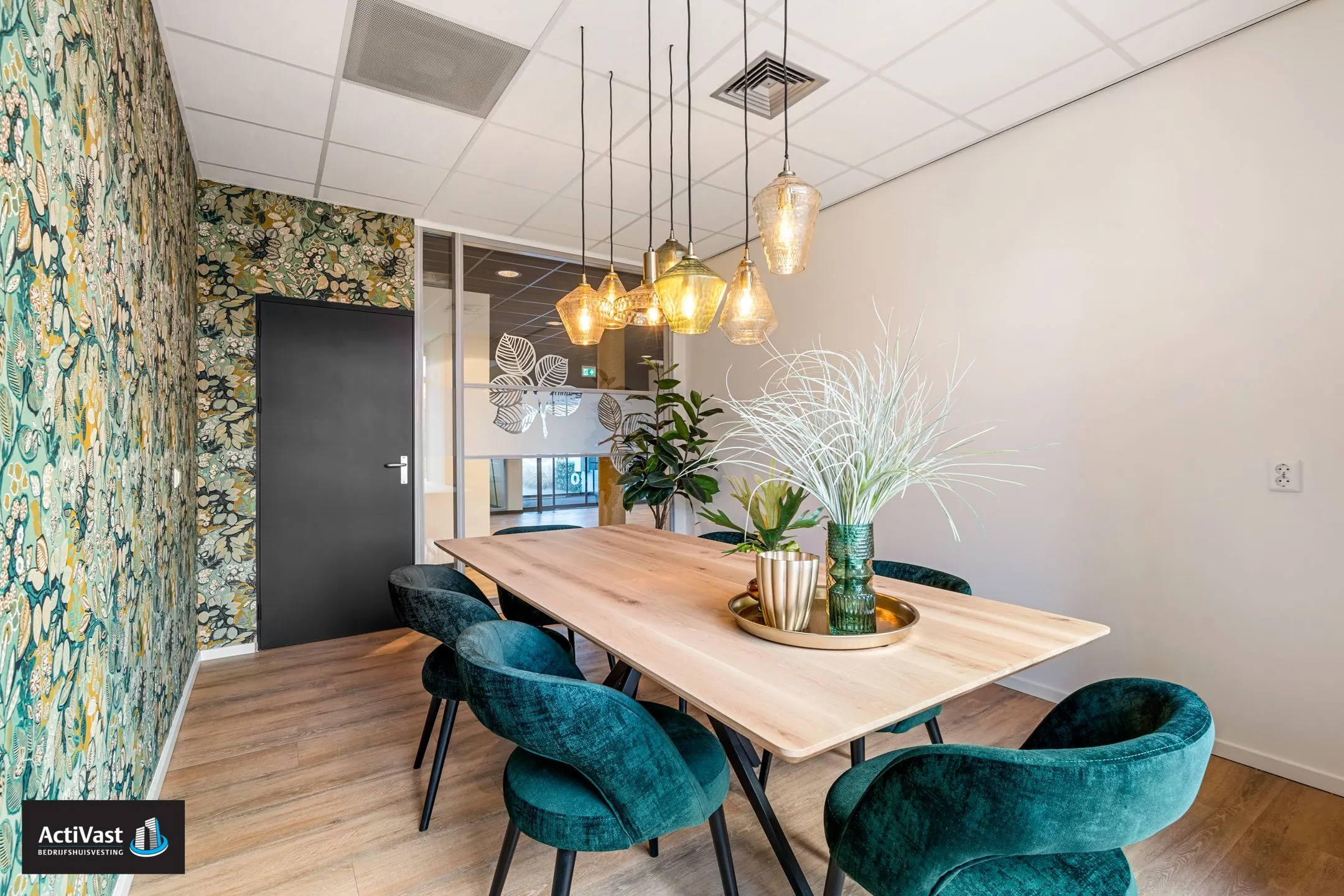 Moderne vergaderruimte in Agro Business Park 22_10 met stijlvolle verlichting, houten tafel en groene velvet stoelen.