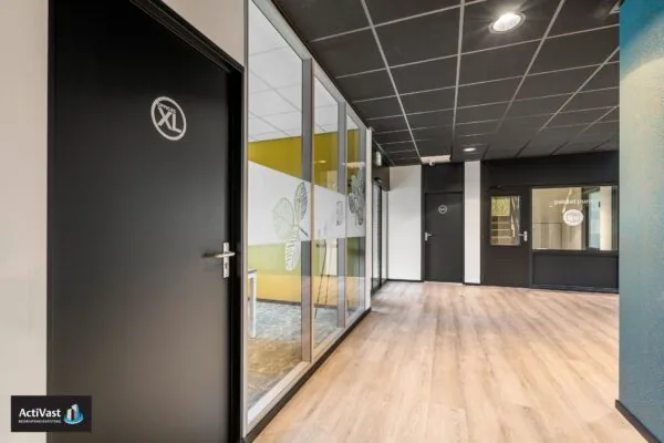 Moderne kantoorhal in Agro Business Park 22 met houten vloer, zwarte deuren en een pakketpunt.
