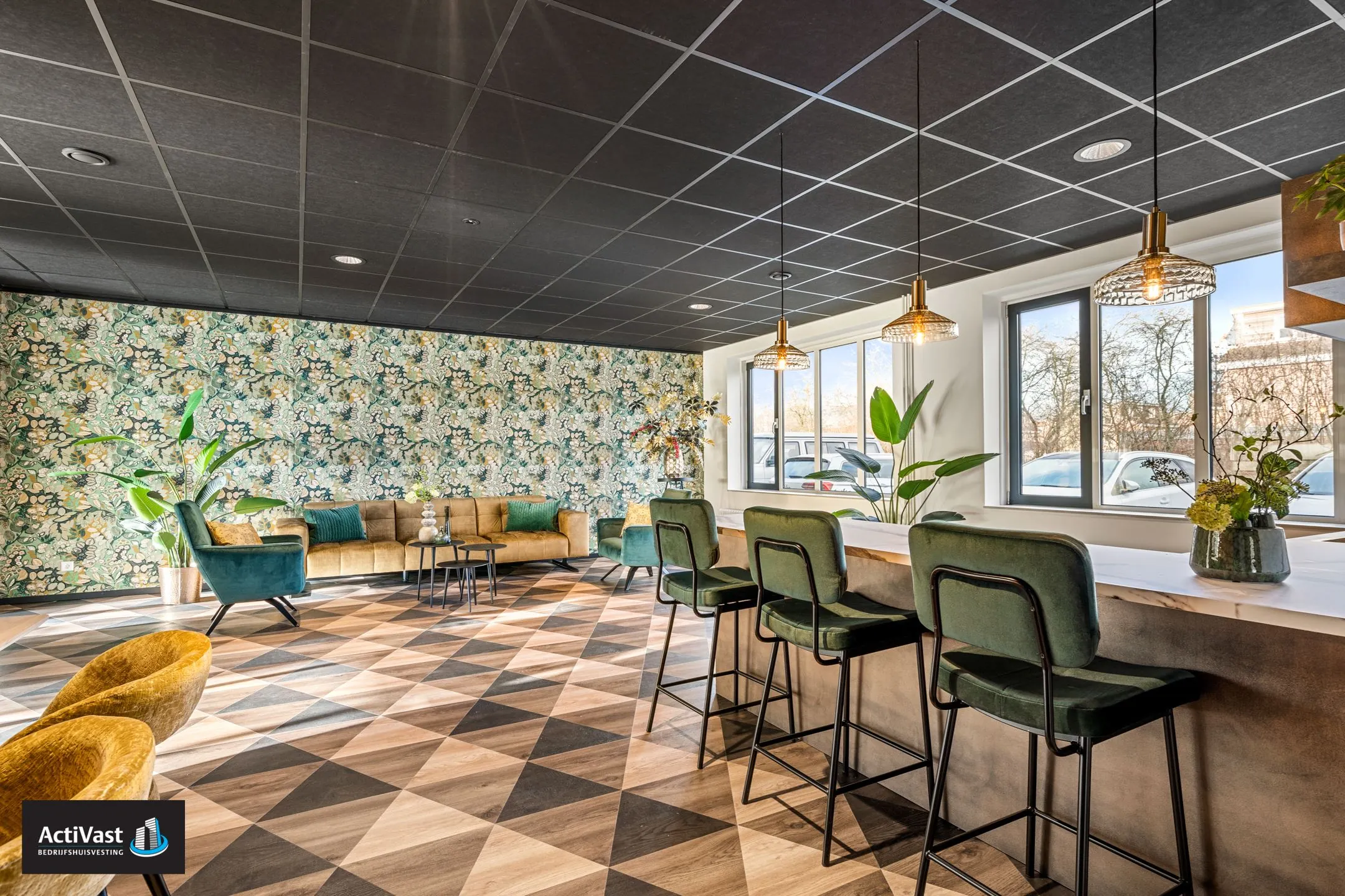 Moderne lounge en ontvangstruimte in Agro Business Park 22 met sfeervolle verlichting, groen fluwelen meubilair en een geometrische houten vloer.