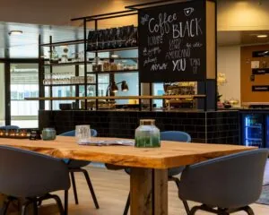 Moderne koffietafel in een stijlvol ingericht kantoor in Almere met een open koffiebar op de achtergrond.
