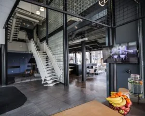 Moderne en open kantoorruimte in Amsterdam-Amersfoort met glazen wanden, een witte trap en een zithoek.