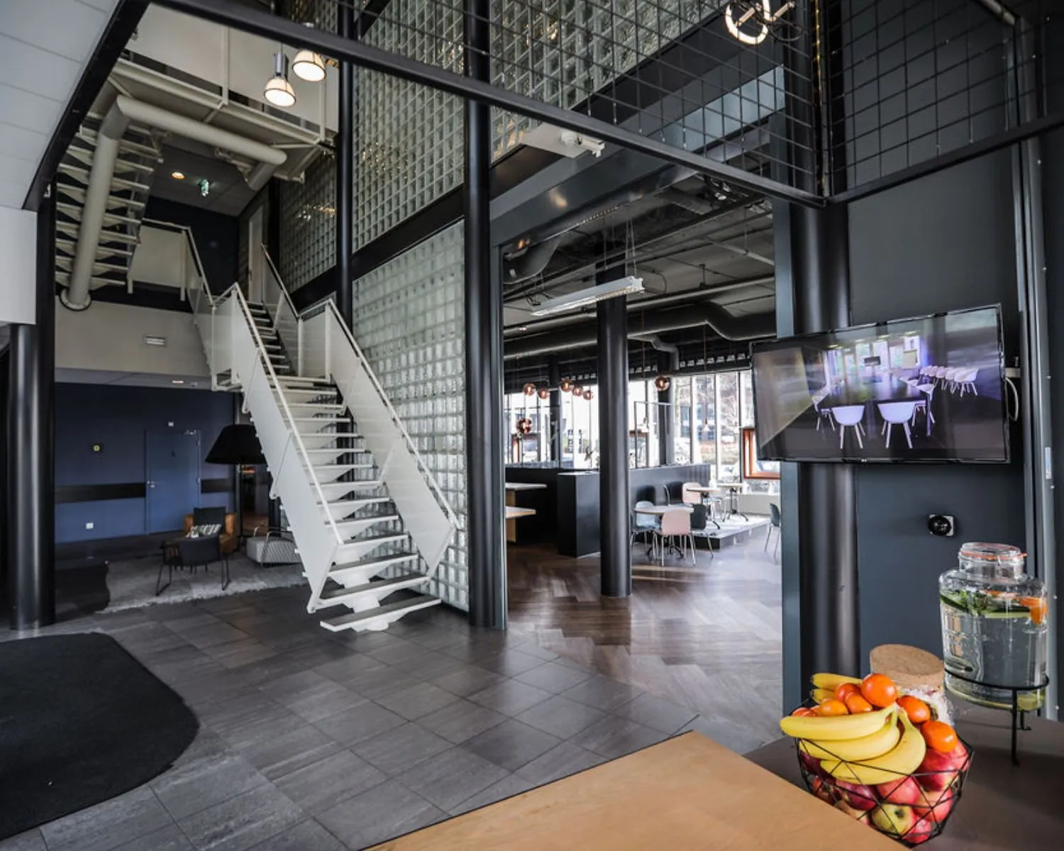 Moderne en open kantoorruimte in Amsterdam-Amersfoort met glazen wanden, een witte trap en een zithoek.