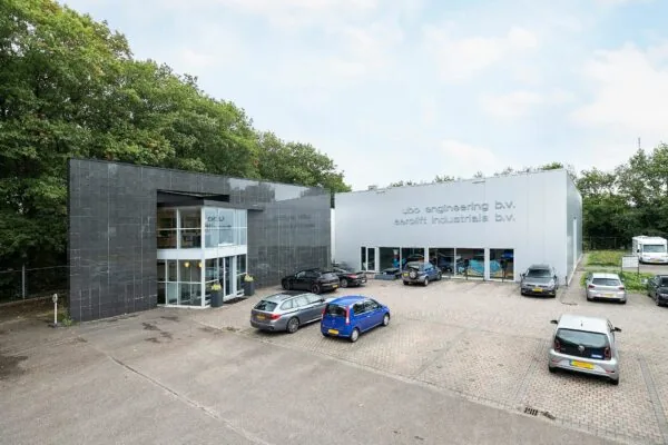 Bedrijfsgebouw aan de Banningstraat 3 met parkeerplaatsen en meerdere geparkeerde auto's voor de ingangen van UBO Engineering B.V. en Aerolit Industrials B.V.