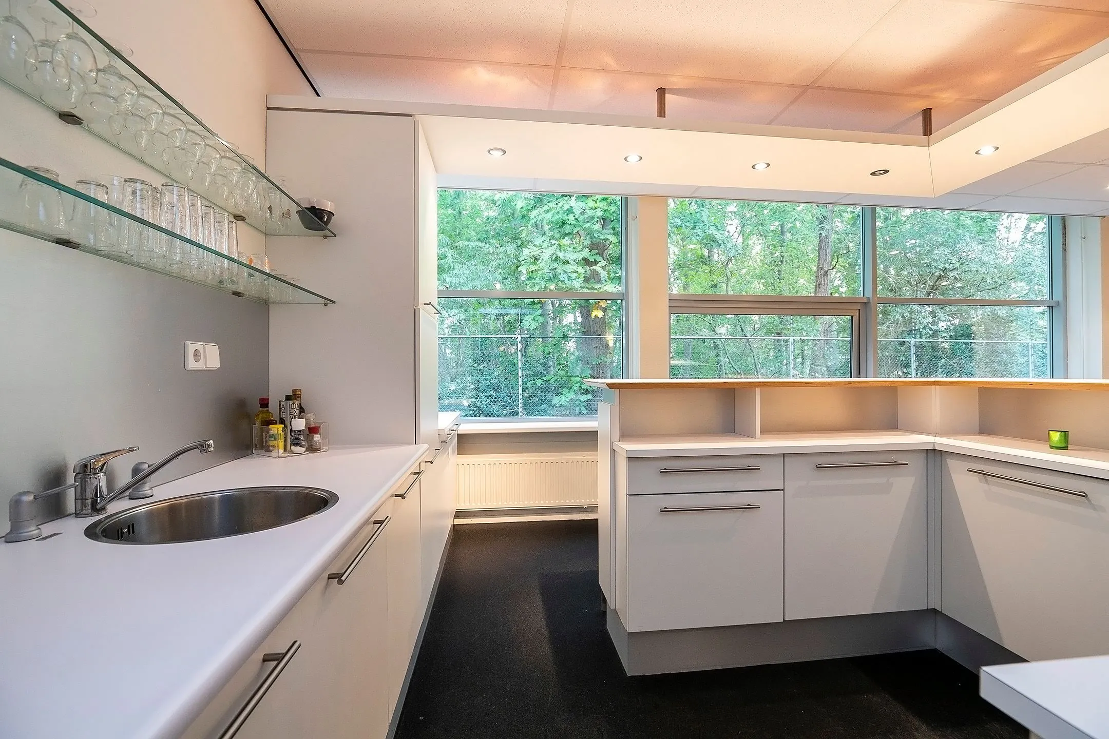 Moderne witte keuken in Banningstraat 3_11 met veel daglicht en uitzicht op een groene omgeving.