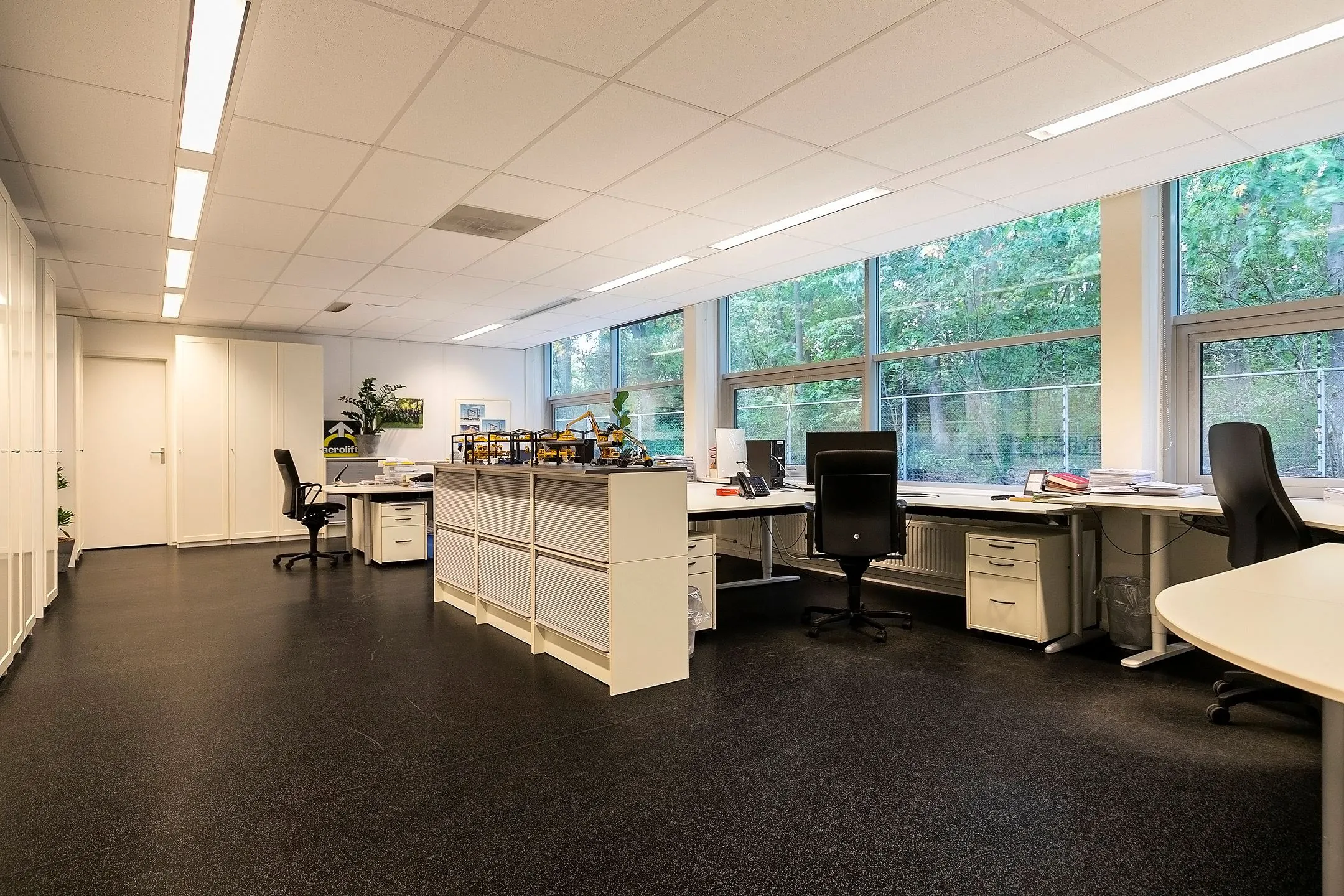 Modern kantoorinterieur aan de Banningstraat 3-7 met meerdere werkplekken en grote ramen met uitzicht op groen.