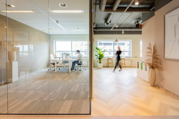 Moderne kantoorruimte aan de Baron van Nagellstraat 136 met glazen vergaderruimte en open zithoek met planten.