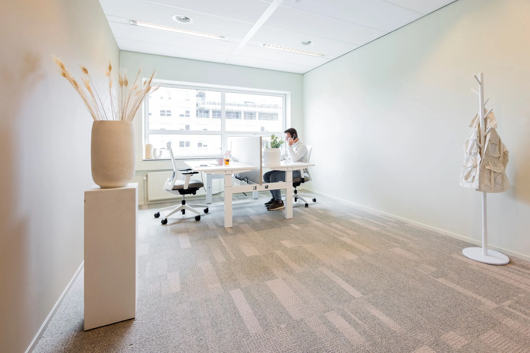 Modern en licht kantoor aan de Baron van Nagellstraat 136 met een persoon aan het werk achter een bureau.