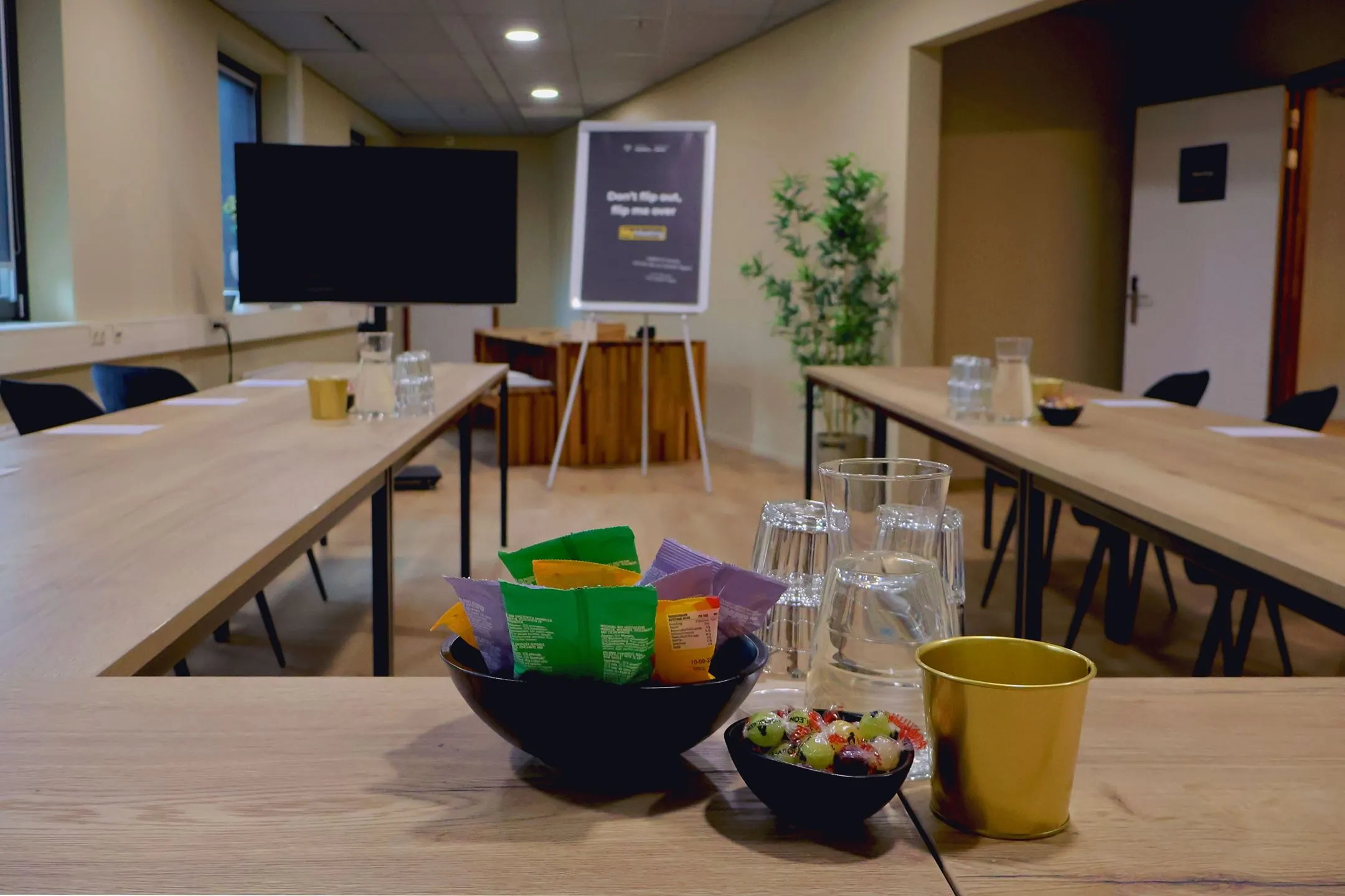 Vergaderruimte Blankenstein 400 met een U-opstelling, voorzien van drankjes, snacks en een presentatiescherm.