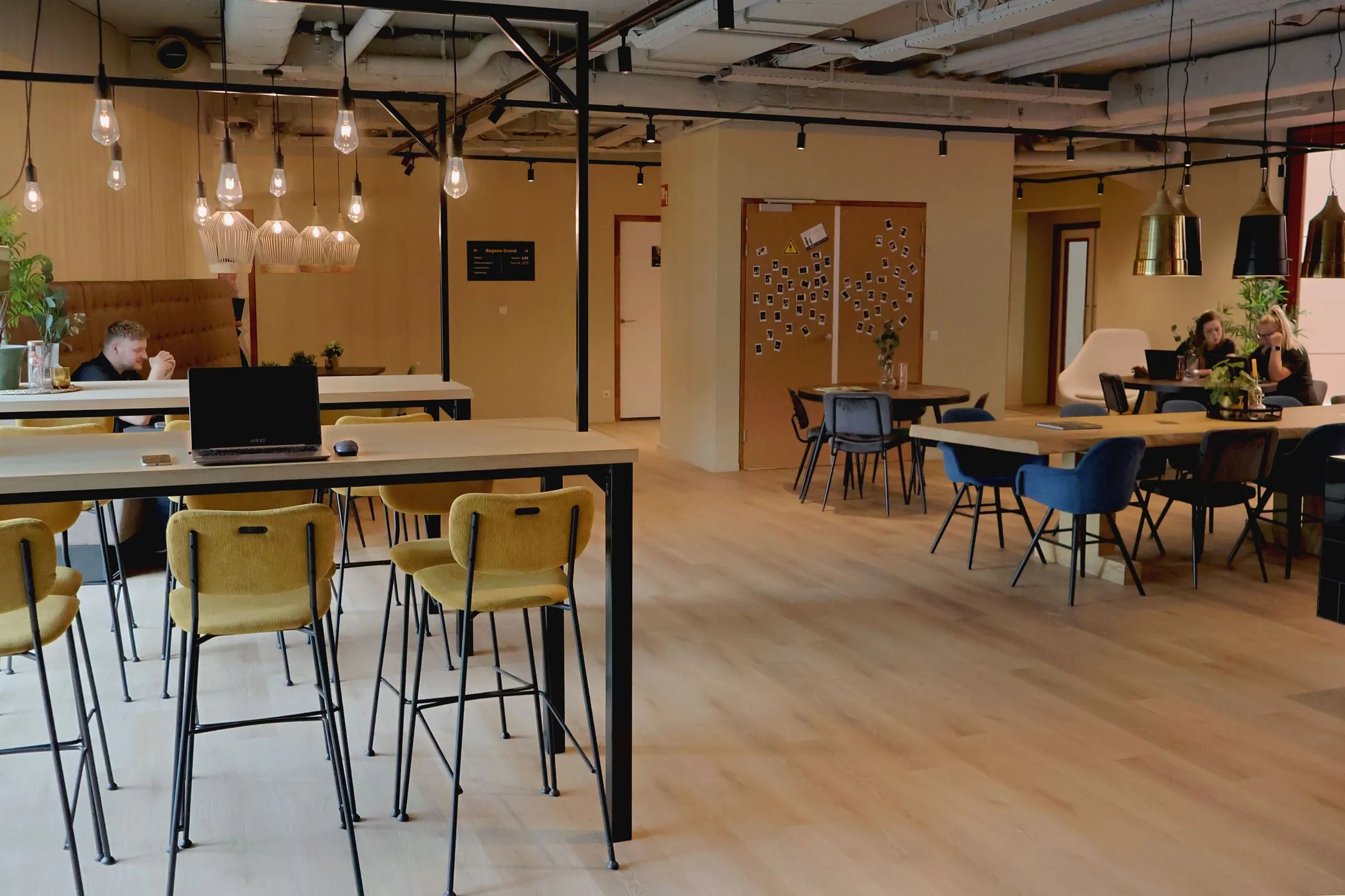 Moderne en sfeervolle gemeenschappelijke werkruimte in Blankenstein 400 met zitplekken, hanglampen en werkende mensen.