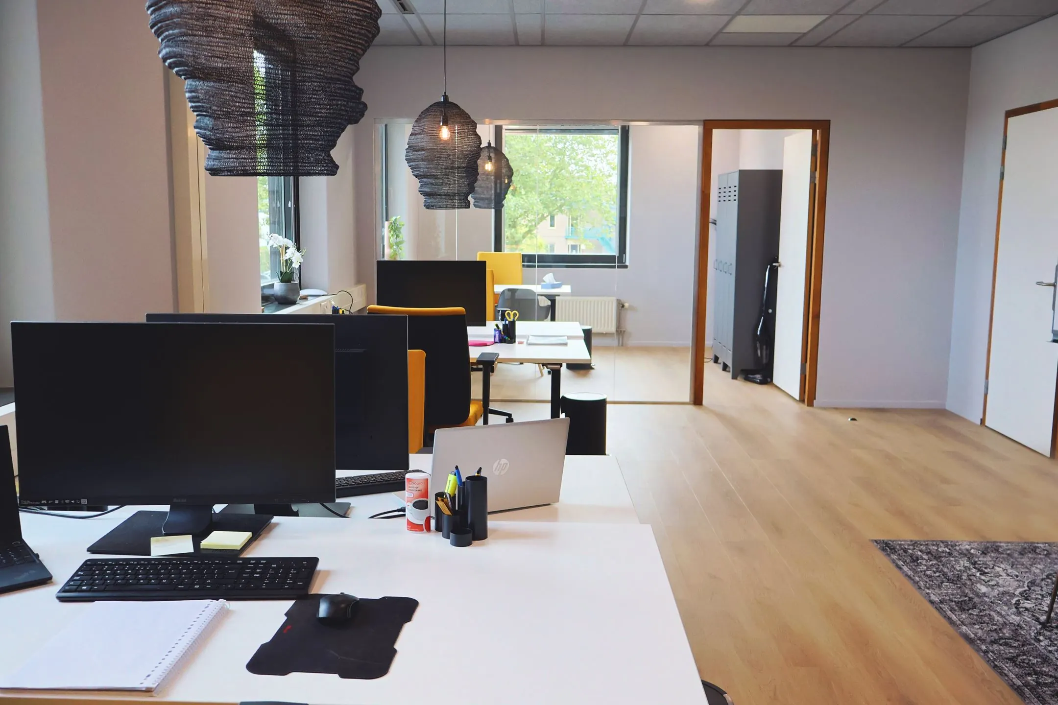 Modern kantoorinterieur van Blankenstein 400 met bureaus, computers en hanglampen in een lichte ruimte.