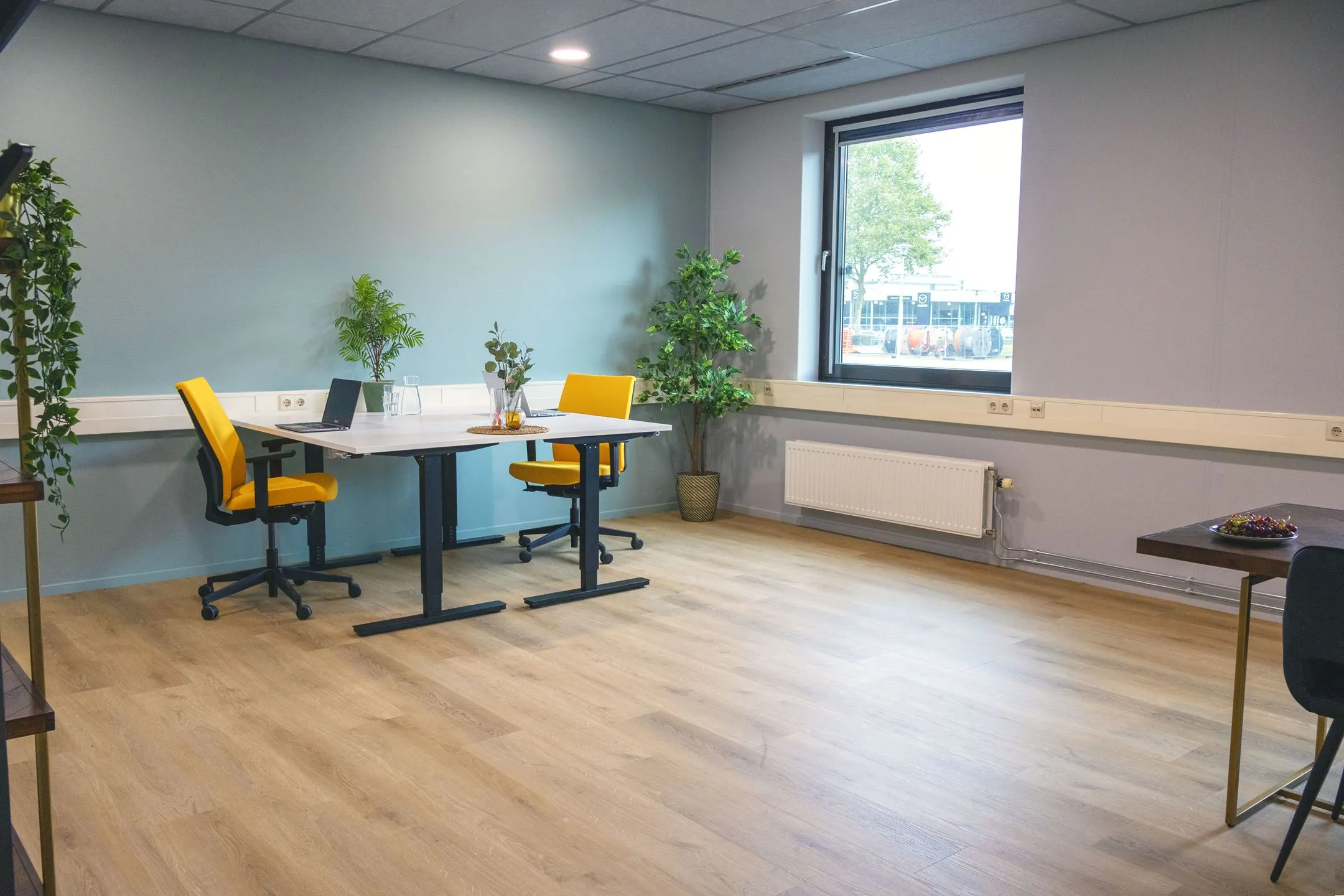 Modern ingerichte kantoorruimte in Blankenstein 400 met twee bureaus, gele stoelen en veel natuurlijk licht.