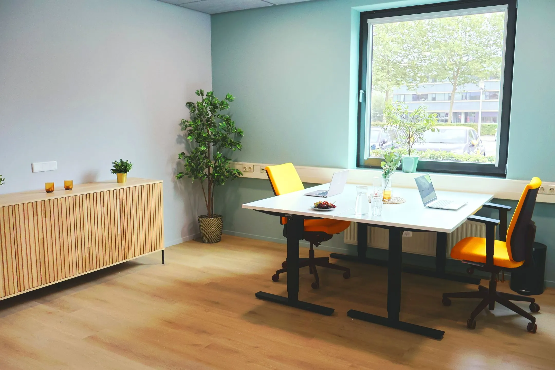 Moderne kantoorruimte in Blankenstein 400 met twee bureaustoelen, laptops, planten en een groot raam met uitzicht.