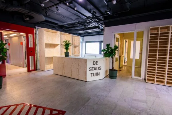 Receptiebalie van Bosquette in De Stadstuin met licht houten inrichting en groene planten.