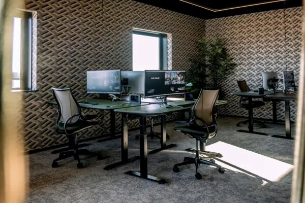 Moderne kantoorruimte aan de Ceintuurbaan 28 met ergonomische bureaustoelen, grote beeldschermen en decoratieve muurpatronen.