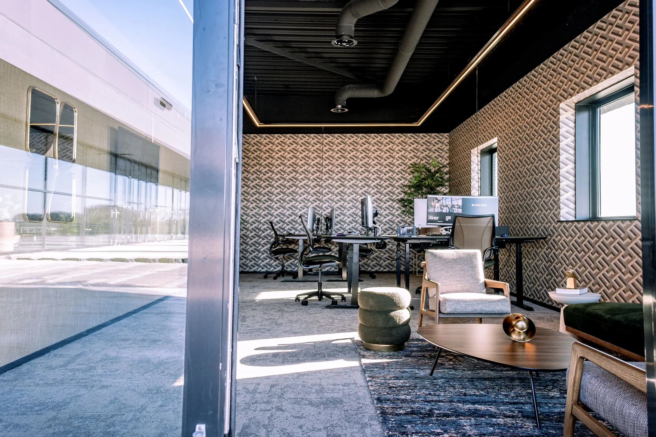 Modern ingerichte kantoorruimte aan de Ceintuurbaan 28_7 met werkplekken, loungehoek en decoratieve wandbekleding.