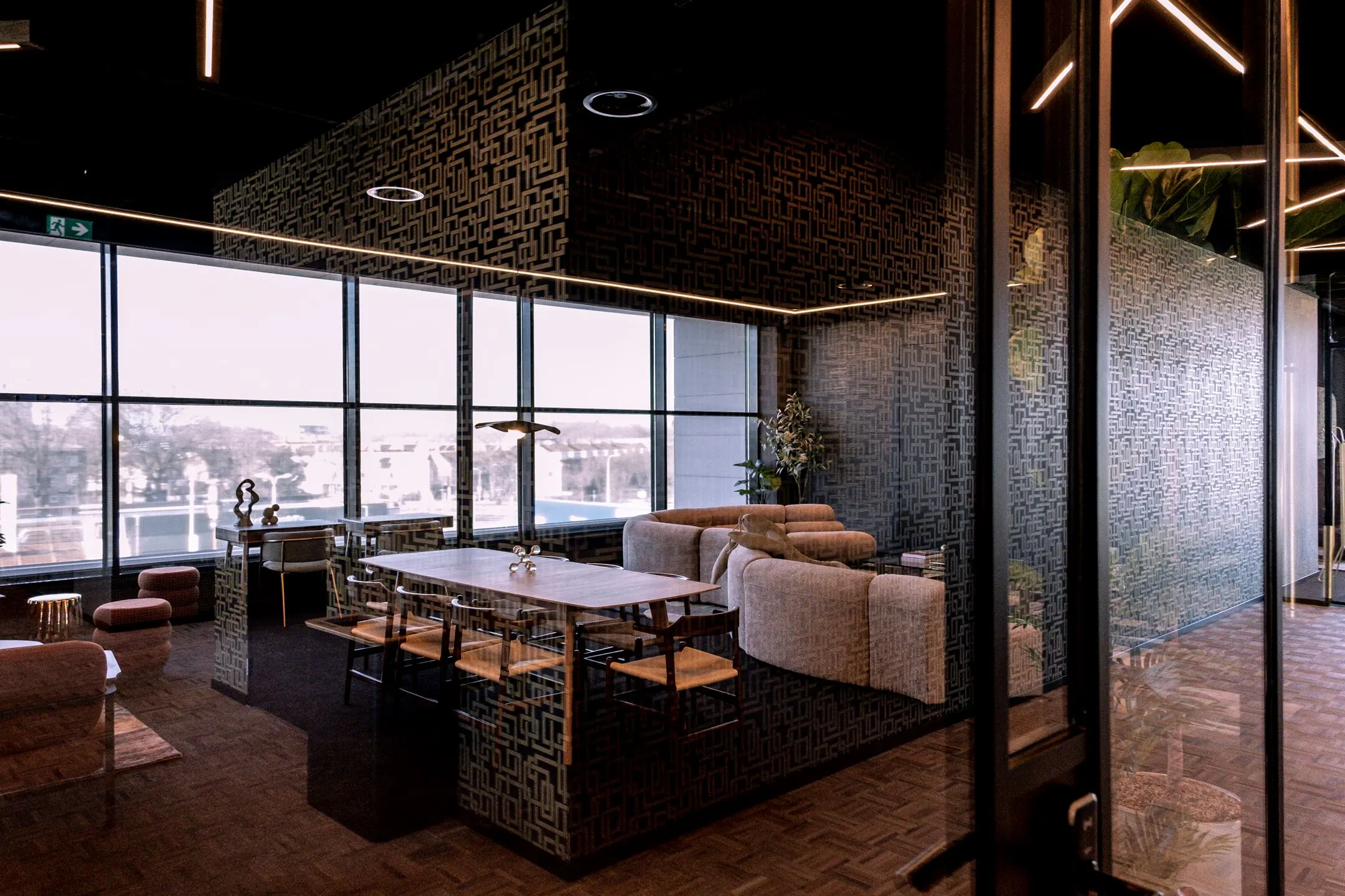 Moderne lounge- en vergaderruimte in Ceintuurbaan 28 met designmeubilair en grote ramen met uitzicht op de stad.